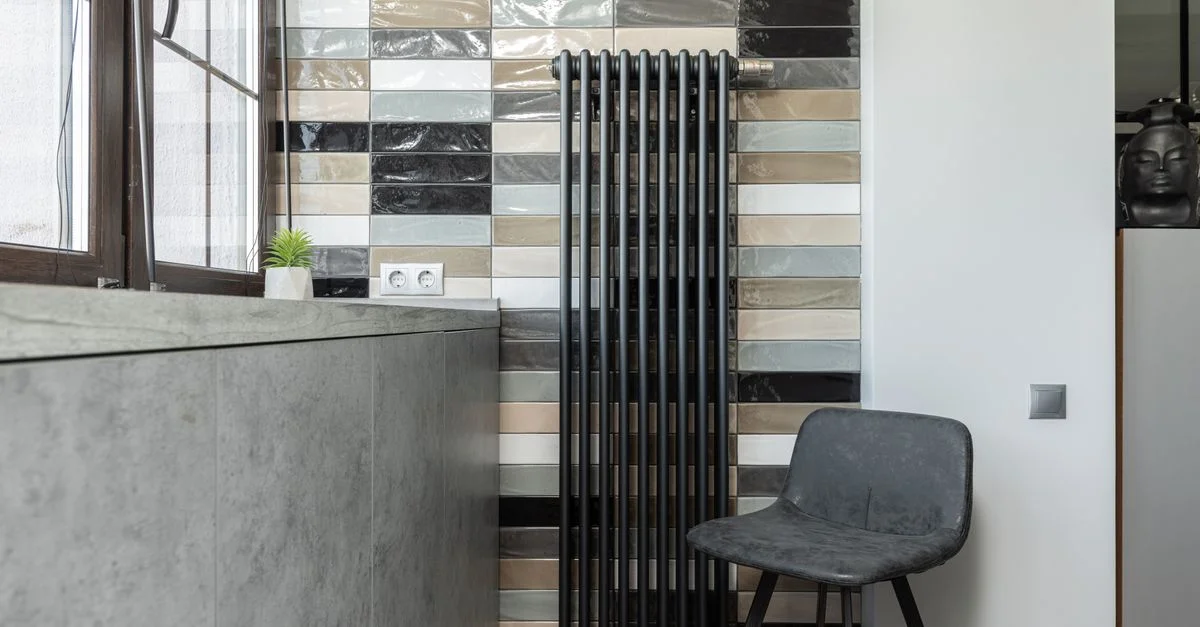 Intérieur élégant avec un mur carrelé, un radiateur et une chaise de designer.