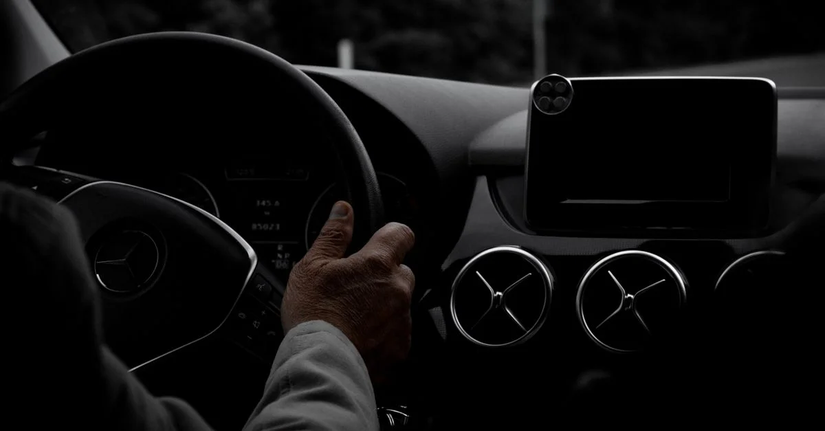Gros plan sur les mains d'un conducteur sur un volant Mercedes-Benz avec une vue du tableau de bord.